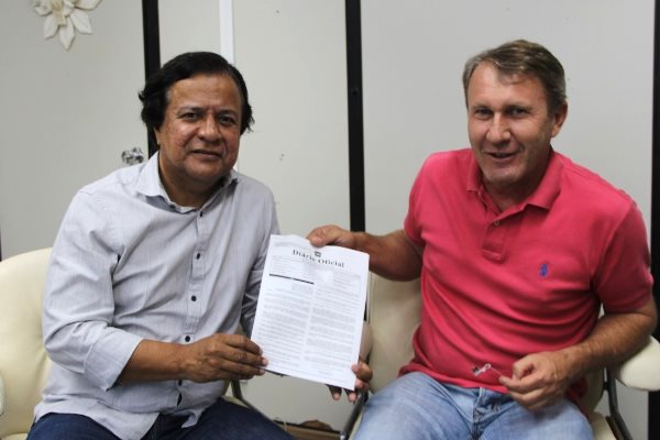 Imagem: Deputado entrega cópia da publicação da lei no diário oficial do Estado de MS ao prefeito do Parque dos Poderes.