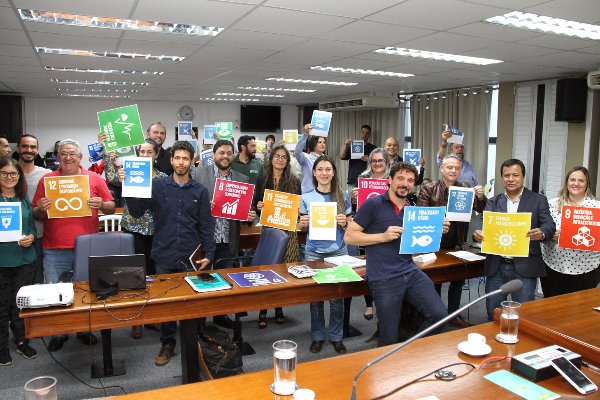 Imagem: Participantes da reunião seguram cartazes com os objetivos para o desenvolvimento sustentável