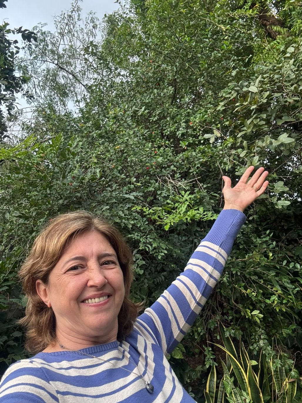 Márcia perto do pé de acerola; planta guarda muitas memórias (Foto: Arquivo pessoal)
