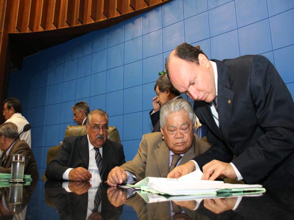 Imagem: Deputados Mochi (PMDB) em pé, ao lado do Akira Otsubo (PMDB) sentado, apreciam o projeto