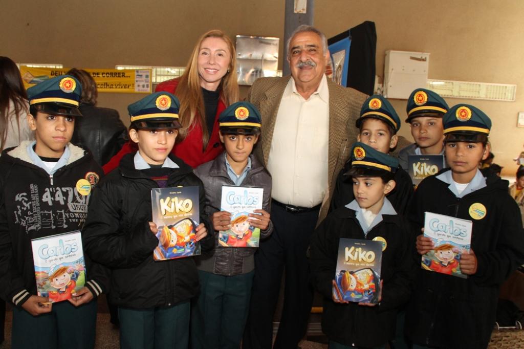 Imagem: Procuradora de Justiça Ariadne Cantú e deputado Jerson Domingos ao lado de crianças durante lançamento de livros.