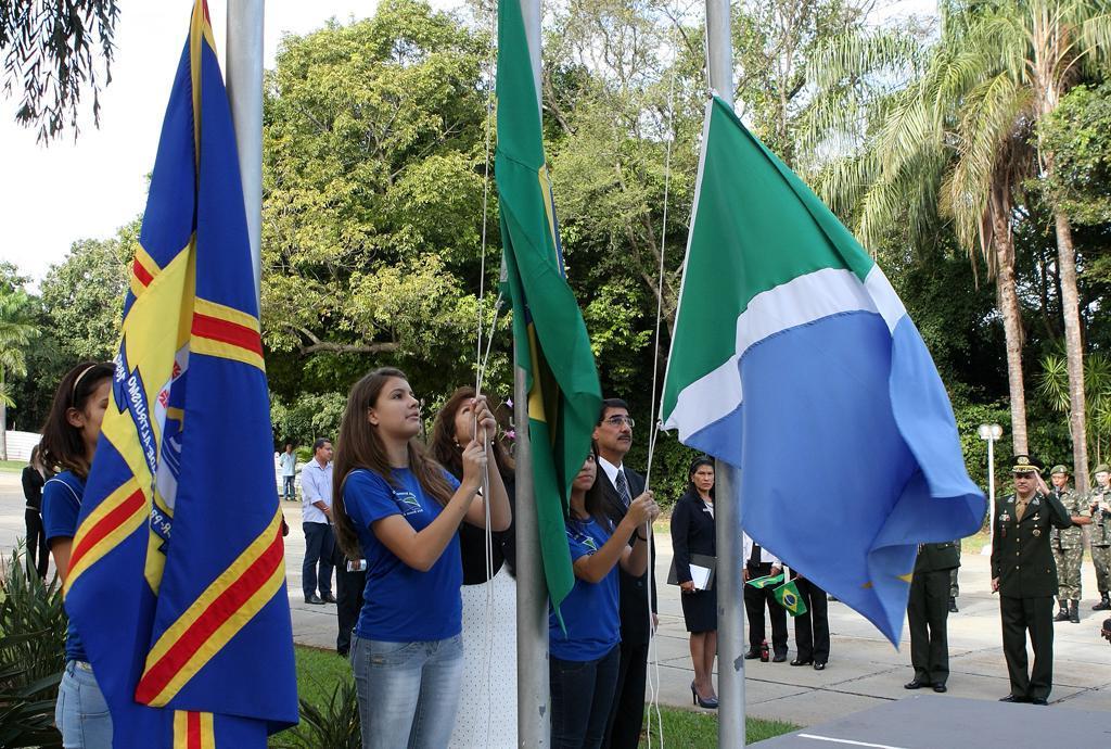 Imagem: Alunos hasteando as bandeiras Nacional, Estadual e Municipal na Assembleia.