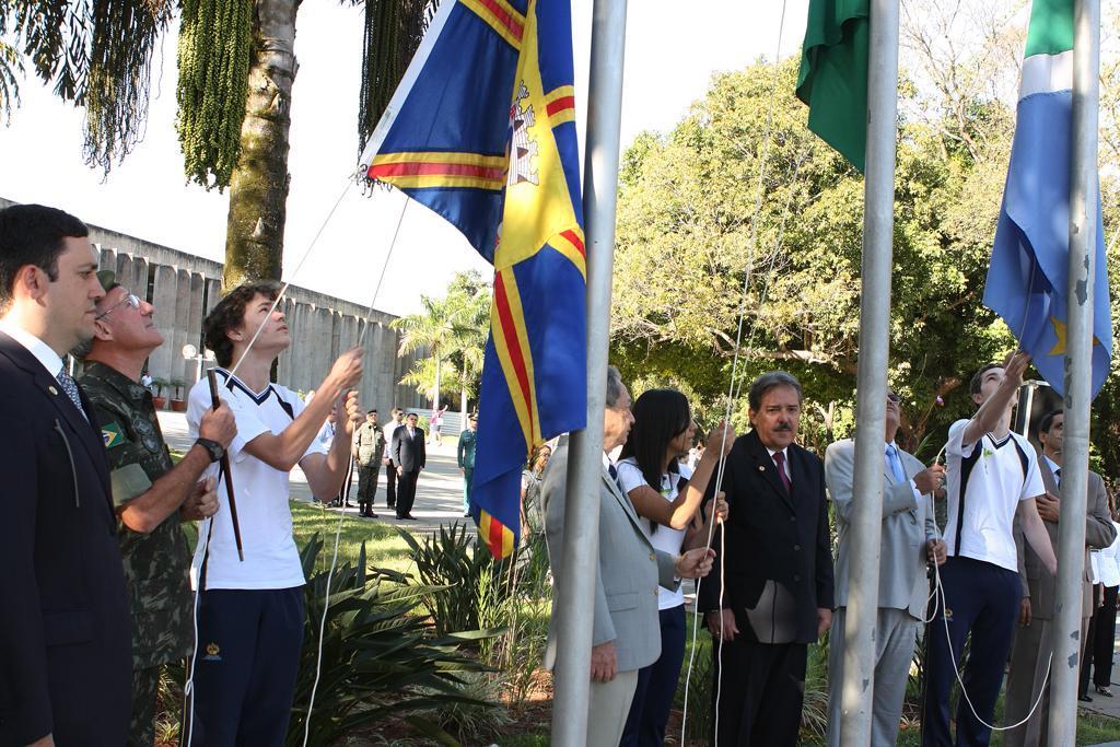 Imagem: Alunos do Colégio Adventista hasteiam bandeiras em frente à Assembleia.